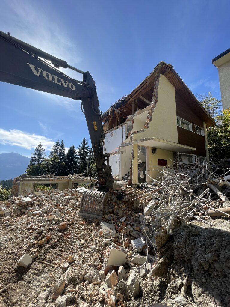 Chantier en station : pelle Volvo en train de démolir un chalet à Crans-Montana
