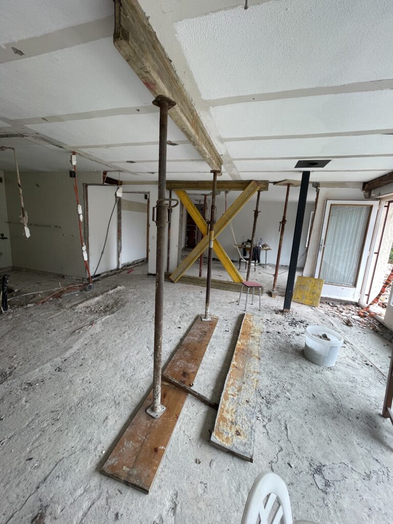 Étais métalliques et croix de Saint-André jaune dans un appartement en travaux