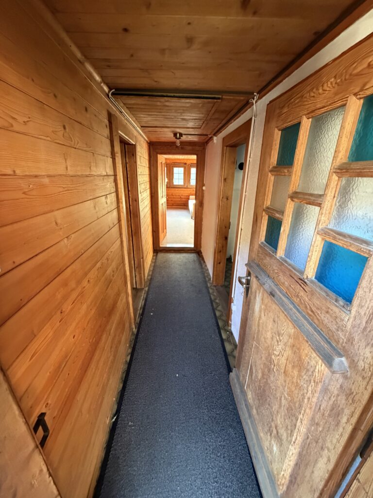 Couloir lambrissé d'un chalet avant démolition intérieure