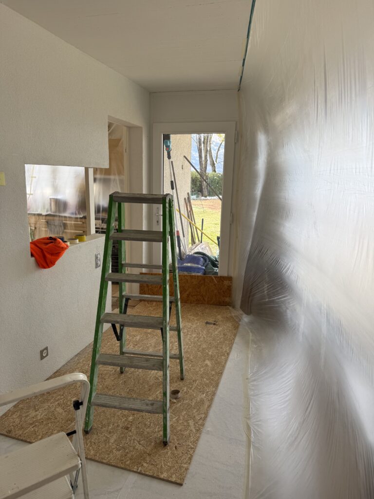 Couloir protégé par des bâches avec une échelle de chantier