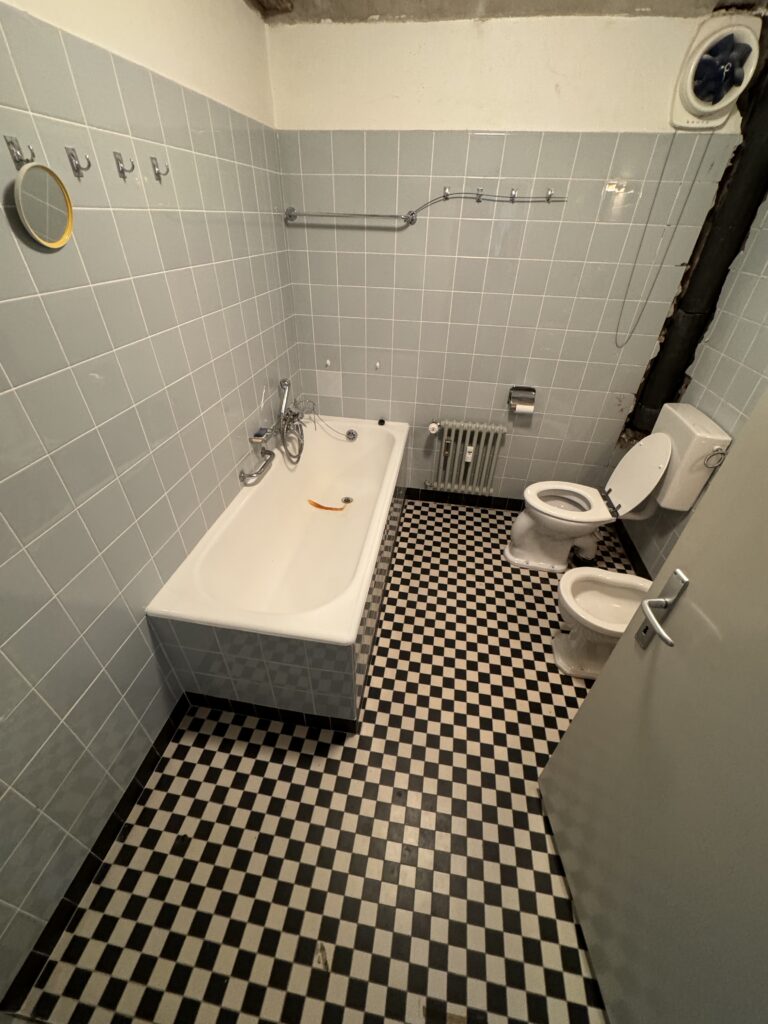 Salle de bain avant démolition, baignoire et carrelage en damier